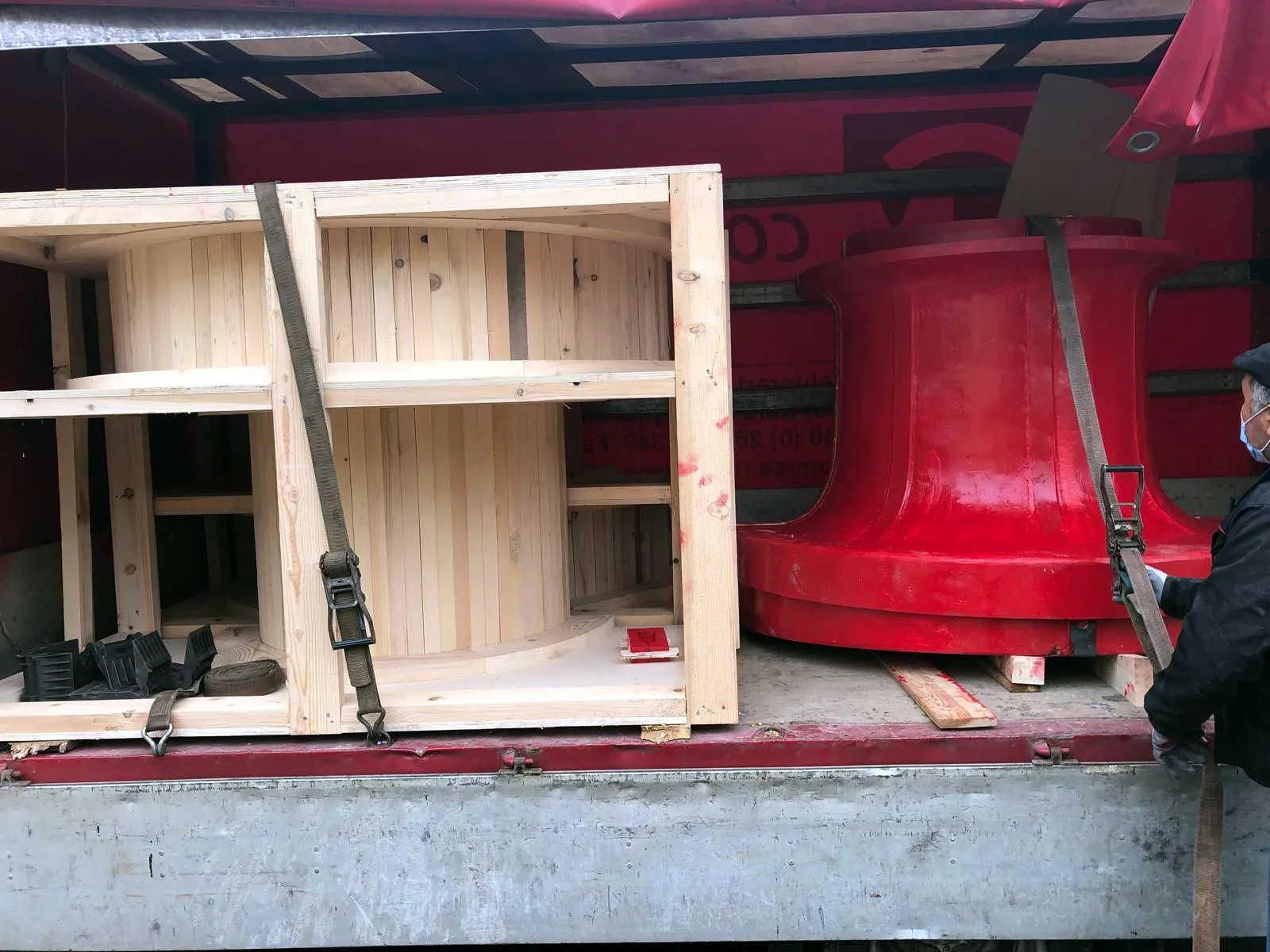 Large red-finished pattern and a crated pattern strapped on a truck for delivery